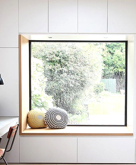a minimalist windowsill reading nook with drawers for storage under it - you can store your books there