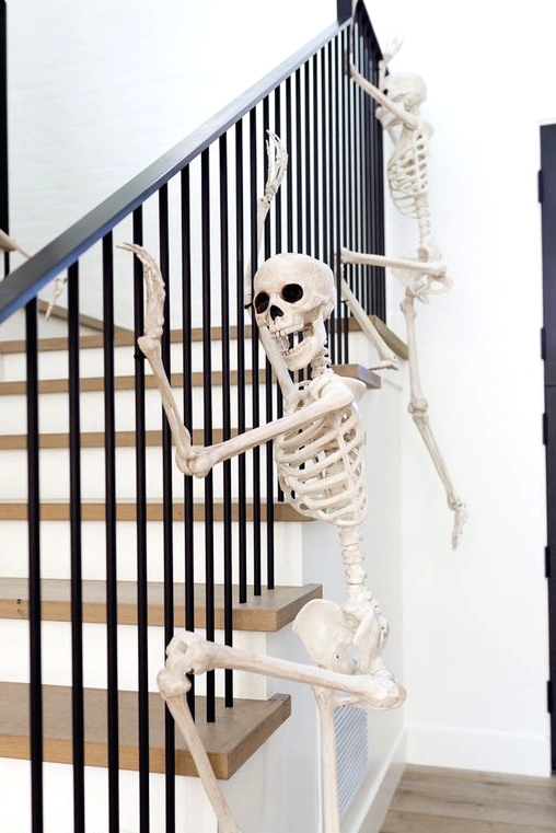 skeletons climbing up the railing are a fun and very easy idea to style your home for Halloween and you can realize that very quickly