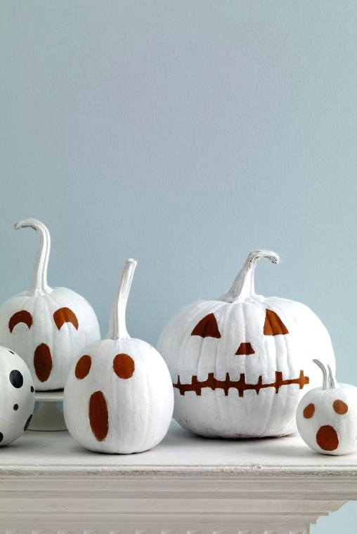white pumpkins with faces painted isntead of carving is a great and fast DIY you can easily realize