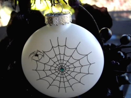 a white Christmas ornament decorated with a spider web and a spider is a cool idea for Halloween and Christmas decor