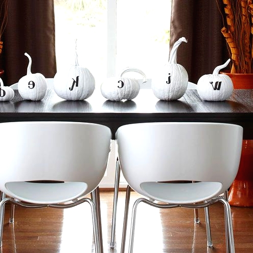 white pumpkins with black letters are a simple and cool white Halloween decor idea to rock right now