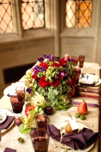 a bold Thanksgiving tablescape with neutral linens, purple napkins and glasses, bold blooms and greenery, pears and succulents is gorgeous