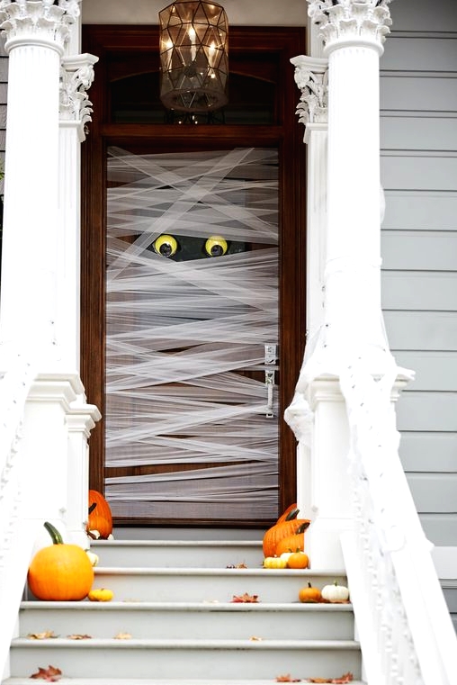 such a mummy-style front door is very easy to make, add a couple of pumpkins and fall leaves on the steps and voila - you have a Halloween porch