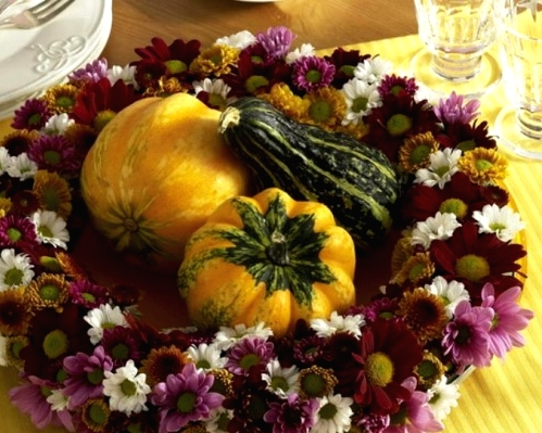 a bold Thanksgiving wreath of purple and white blooms and gourds and pumpkins in the center can double as a centerpiece for a party