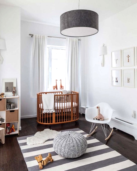 a serene Scandi nursery with a rich-stained crib and all the rest done in grey and white, with a grid gallery wall and some lovely toys