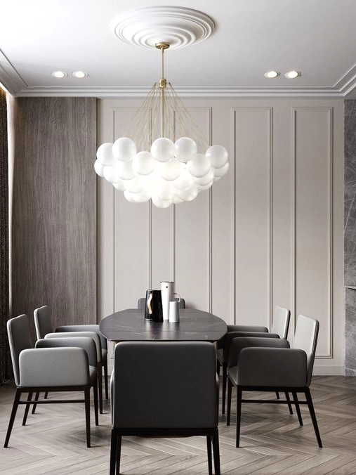 an exquisite greige dining room with paneled walls, stained wood, a black dining table, grey chairs and a bubble pendant lamp