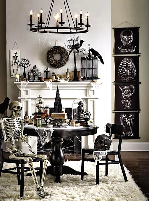 a vintage Halloween space with black posters, skeletons and skulls, blackbirds and wreaths, black furniture and a candle chandelier is wow