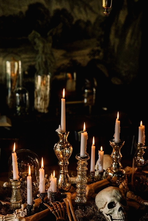 elegant vintage Halloween decor with a skull, skeleton hands, mercury glass candleholders and tall and thin candles is wow