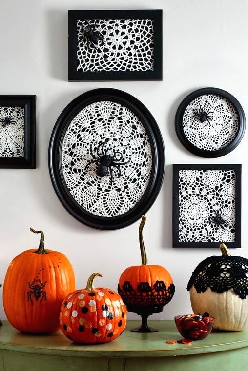 vintage Halloween console styling, with white doilies in black frames, spiders, bold pumpkins with polka dots and in doilies plus a candle