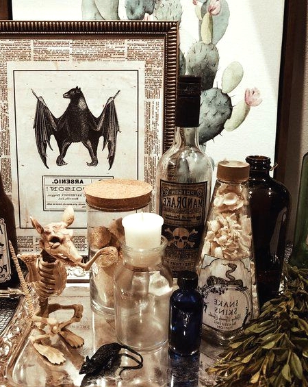 vintage apothecary Halloween decor with a rat skeleton, apothecary bottles, signs and a silver tray is cool and chic