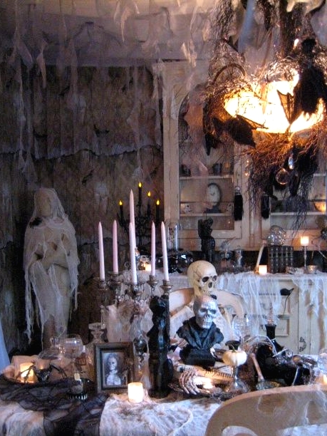 a stunning vintage Halloween haunted space with net as spider webs, tall candles, skulls and skeletons, blackbirds and bats is a cool idea for a party