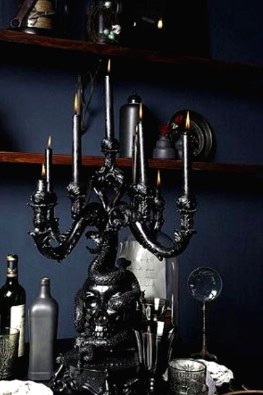 a chic black vintage Halloween candelabra with black candles, vintage glasses and bottles for a beautiful and stylish tablescape