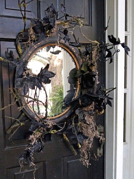 a black mirror with branches, twigs, black leaves and blackbirds is a lovely front door decoration for those who love vintage Halloween decor
