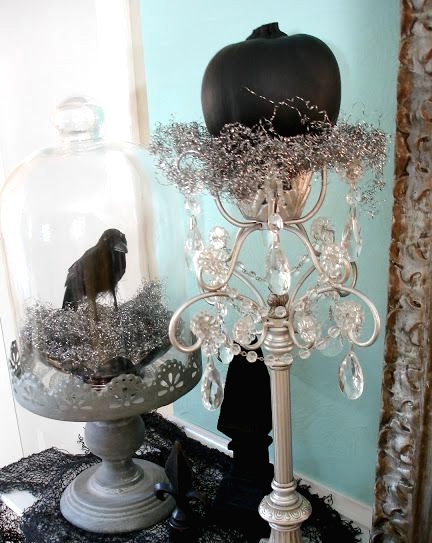 vintage Halloween decor with a tall stand and a cloche, crystals, shiny hay, a black pumpkins and a blackbird is a beautiful idea to DIY