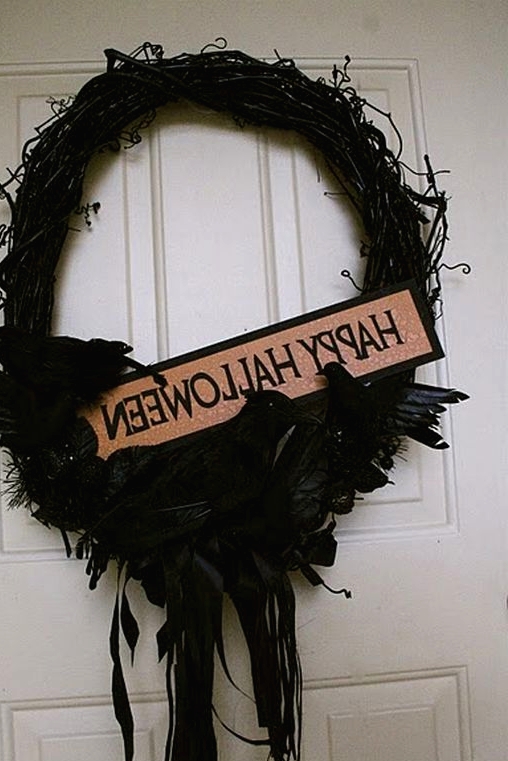 a black Halloween wreath of vine, with blackbirds, feathers and ribbons plus a mini sign is a creative and bold solution