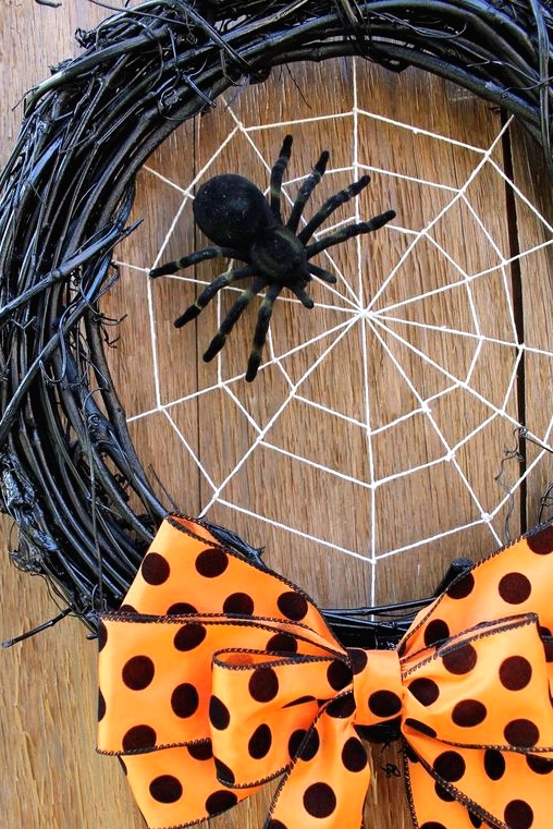 a bold Halloween wreath of black vine, a spider web and a black spider plus an orange polka dot bow for an accent