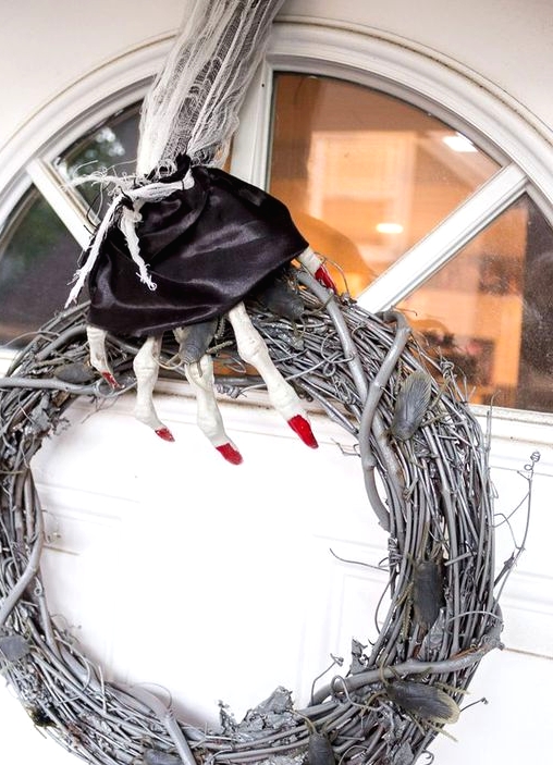 a unique Halloween wreath of whitewashed vine, leaves, a skeleton hand with red nails and a black silk cover is amazing