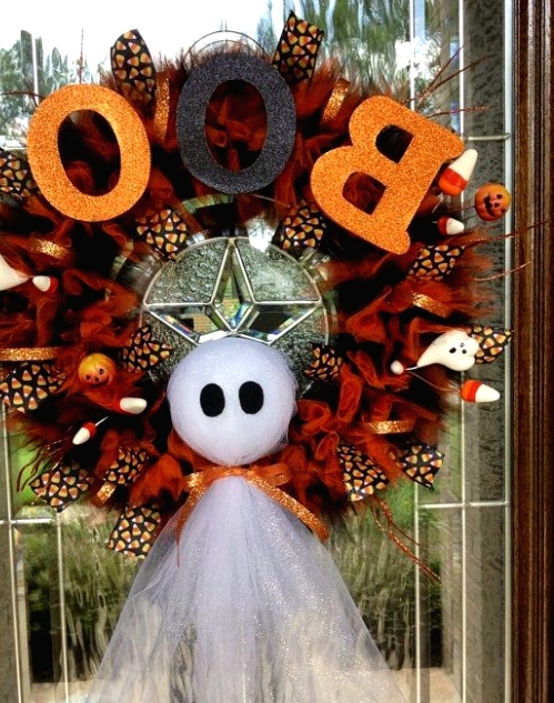 a bold Halloween wreath in rust and black, with a ghost, glitter letters and mini ghosts and corn candies is a lovely idea for the fall