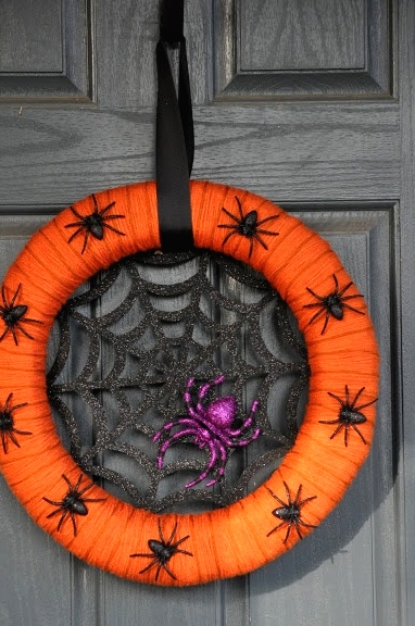 a bold and pretty Halloween wreath of an orange form, a glitter spider net, a purple glitter spider and some black mini spiders on the wreath form