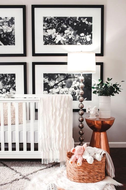 a colorful contemporary nursery with a white crib, a chair, a rattan stool, an emerald sideboard, colorful bedding and an artwork