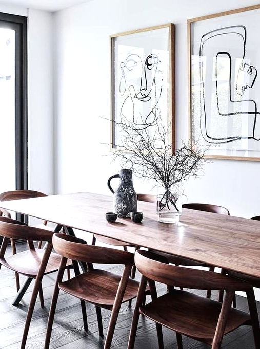 a catchy modern Scandi dining space with a stained table, stained rounded chairs and a mini gallery wall and vases