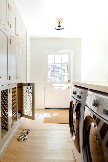 a neutral laundry room with shaker cabinets and lower cabinets turned into a multiple dog crate is a lovely solution