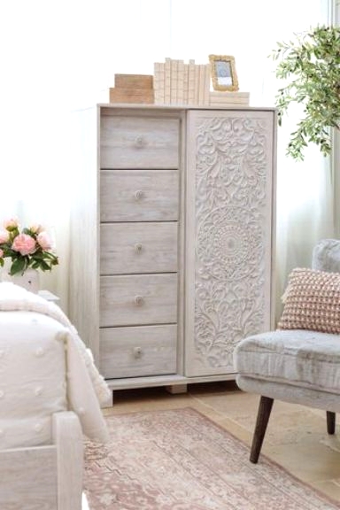 a delicate whitewashed storage unit with five drawers and a beautiful carved door is a lovely solution for a shabby chic bedroom