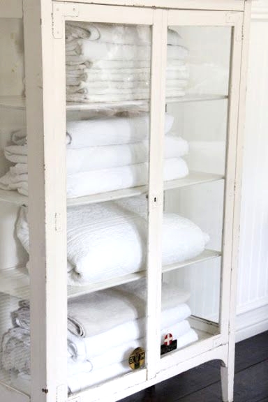 a whitewashed glass wardrobe with lots of shelves is a great solution for a bathroom with a slight vintage feel, and it will display anything else you want