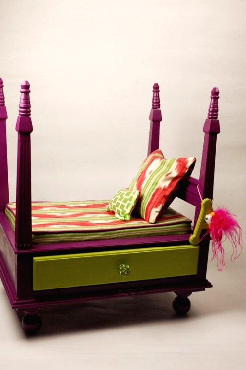 a colorful dog bed on round legs, with a drawer, pillars and colorful bedding is a very chic and bold idea