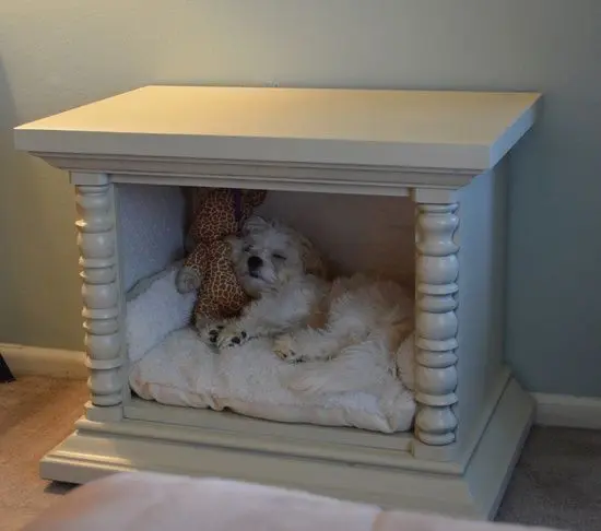 a vintage white cabinet turned into a little dog bed, with a large cushion and a favorite toy is ideal for a bedroom