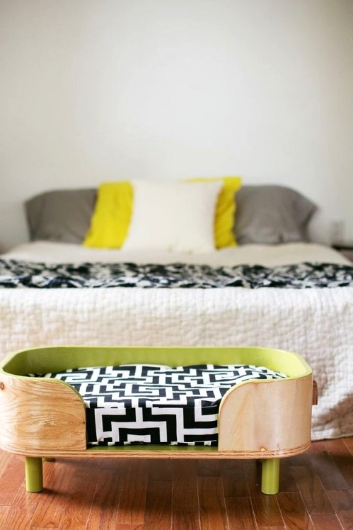 a stylish rounded plywood bed with a green inner and green legs, with a printed cushion is a cool idea for a modern space