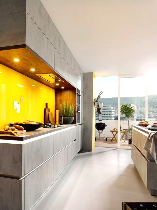 a grey concrete-looking kitchen with dark staiend butcherblock countertops and a bold glossy yellow glass backsplash