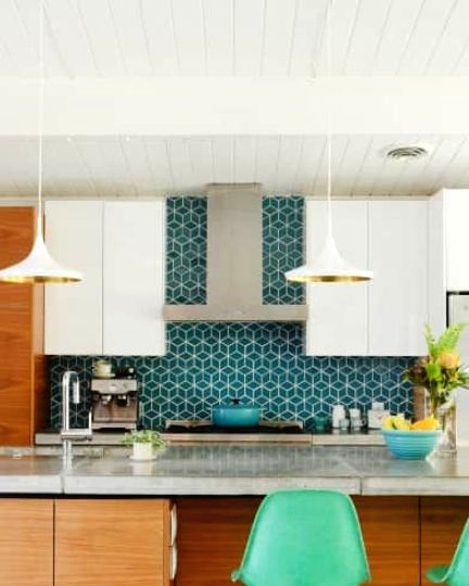 a light-stained and white kitchen with sleek cabinets and a bold blue geo tile backsplash that adds interest and color to the space