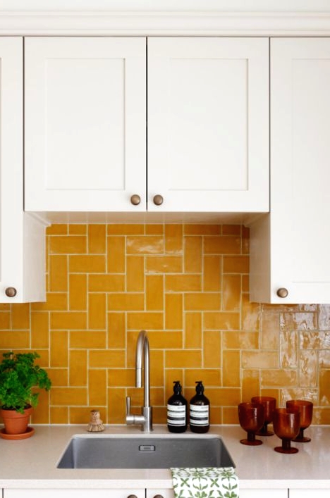 a white shaker style kitchen with a bold yellow tile backsplash that makes a color statement and creates a mood in the space