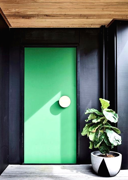 a black entrance with a whitewashed deck and an apple green front door accented with a large round white knob