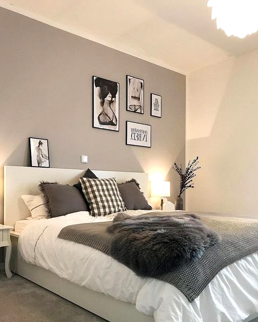 a catchy modern bedroom with a taupe accent wall, a creamy bed with taupe and white bedding, a small gallery wall