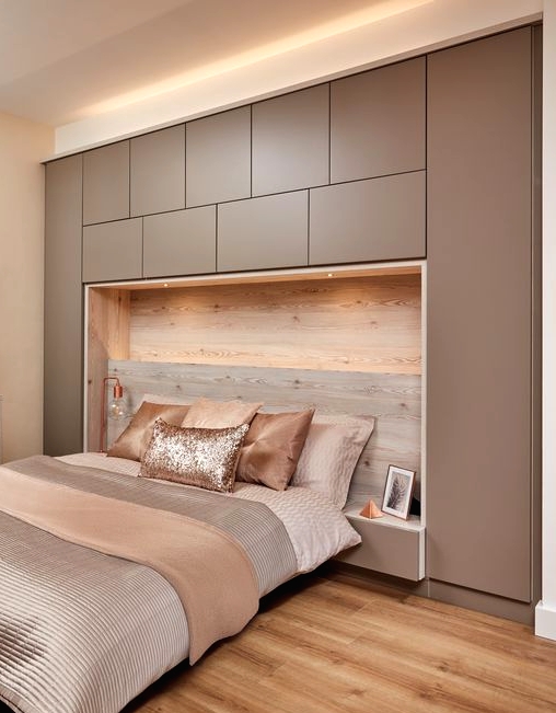 a modern bedroom with a taupe sleek storage unit, a retrasting bed, taupe and blush bedding, a taupe dresser is very welcoming