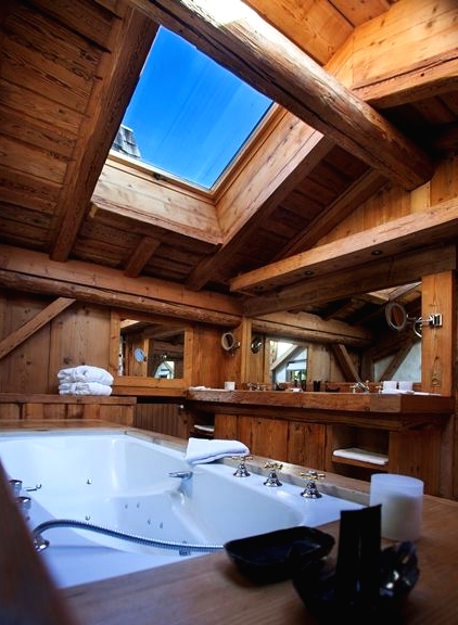 a chalet bathroom fully clad with wood, with a skylight, a bathtub clad with wood, with all wood everything is amazing