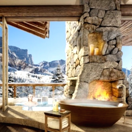 a chalet bathroom with a stone fireplace, a wooden bathtub, folding doors and gorgeous views is amazing
