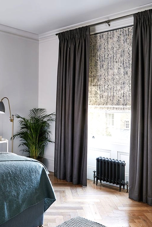 a printed shade and black curtains to block out all the sunshine and make this bedroom as private as possible