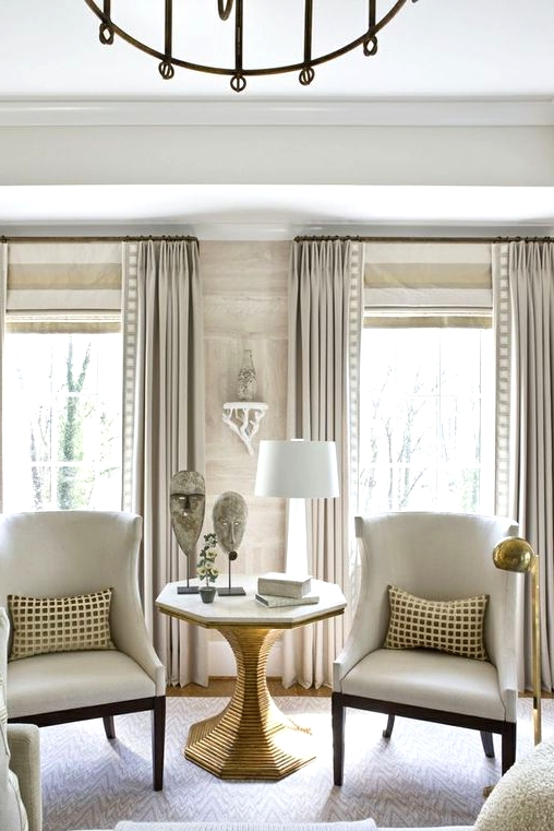 neutral striped shades and off-white draperies with prints are a catchy idea for this neutral space and prints add chic and elegance