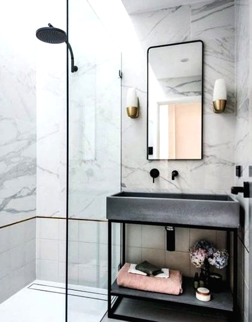 a glam bathroom clad with white marble, with tiles, a concrete sink and black fixtures to give it a fresher modern feel
