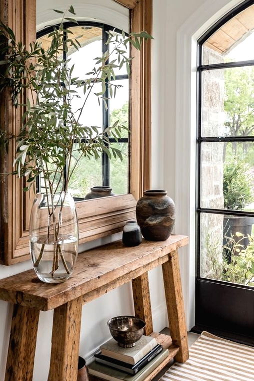 a reclaimed wood console table in the entryway gives it a warm and farmhouse feel easily and effortlessly