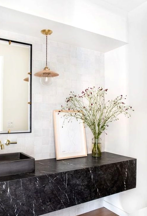 a refined bathroom with a black marble slab floating vanity that brings luxury and chic to the space
