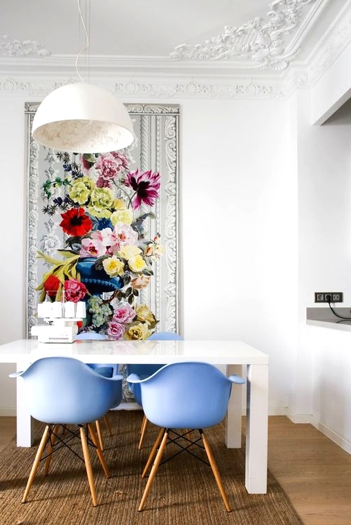 a refined dining space with a simple white table, periwinkle chairs and a bold floral artwork that sets the tone in the room