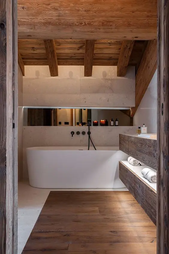 a beautiful chalet bathroom clad with white stone and rich-stained wood, with a floating vanity and a large bathtub is amazing