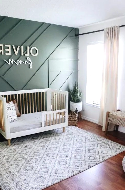 a chic contemporary nursery with a green paneled wall, mid-century modern furniture, neutral textiles and potted greenery