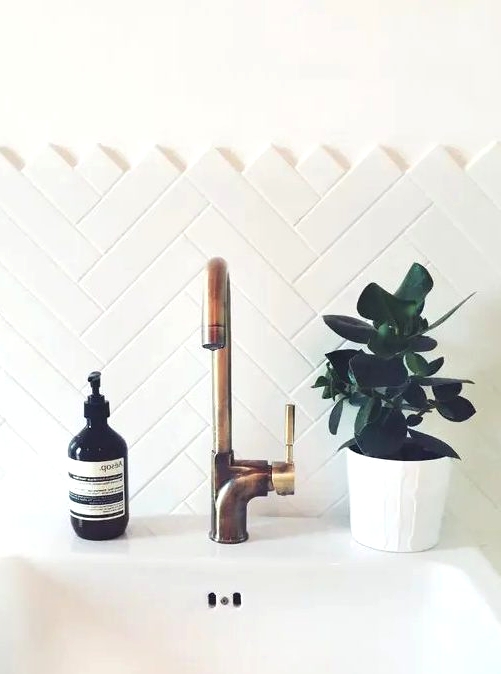 clad a bathroom backsplash with long and narrow tiles with a chevron pattern and it will look bolder
