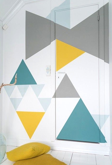 a geometric accent wall and door and mustard pillows that match the colors of the wall