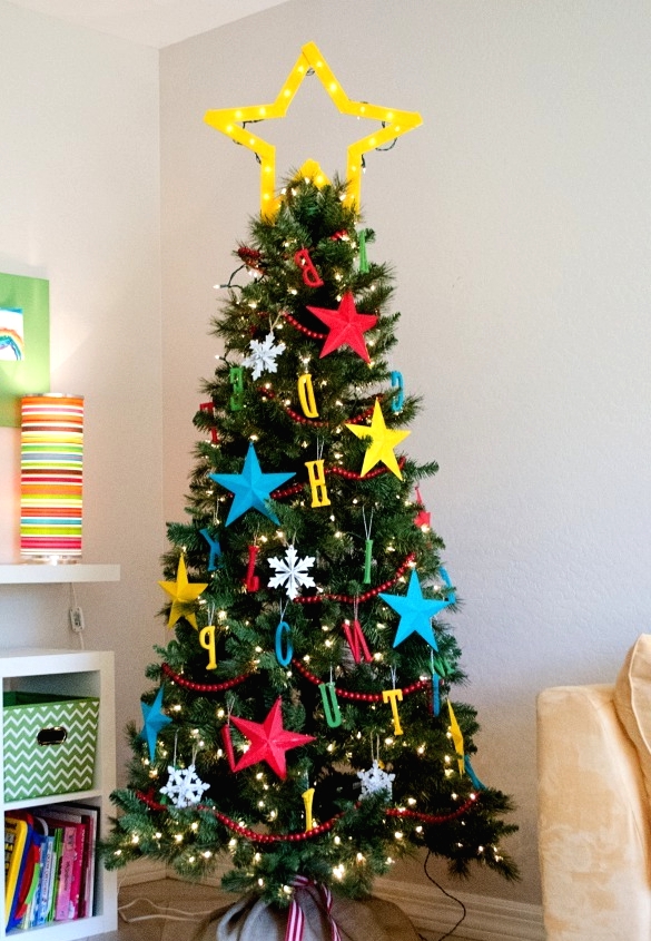 a shiny marquee star tree topper is a great solution for this colorful kids' Christmas tree with letters and stars